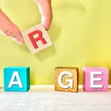 「TARGET」の文字になるよう木のブロックを並べる手