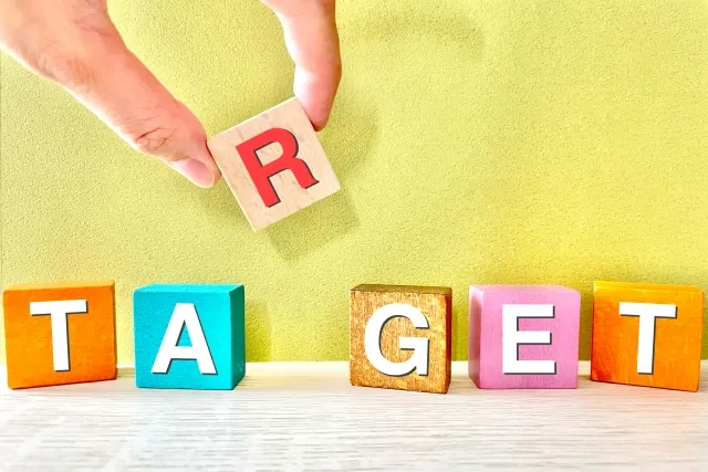 「TARGET」の文字になるよう木のブロックを並べる手